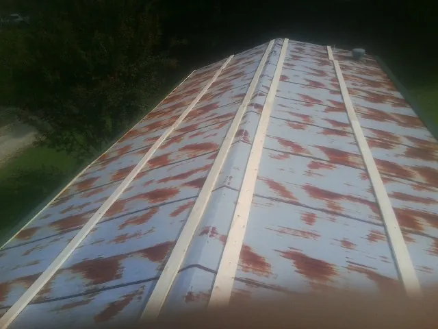 Rusted metal roof panels with new wood purlins before replacement — Storm Damage Roof Repair in La Grange by Roofing Brothers
